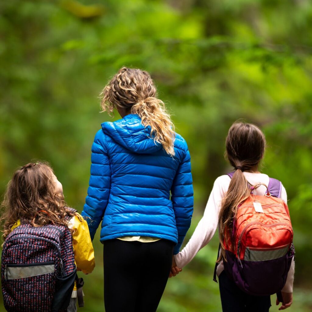 adult and two children walking in the woods
